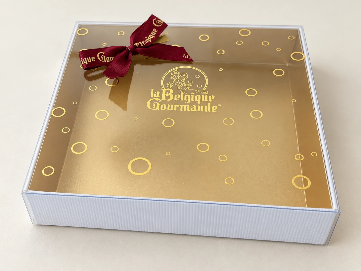 Square gift box with a clear printed lid and a satin ribbon